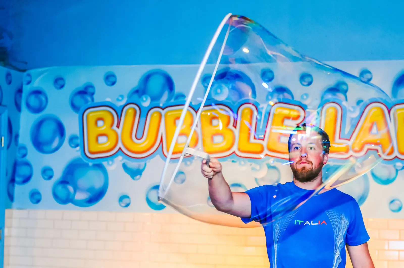 Man pulling a giant soap bubble through the air in the Bubble Lab