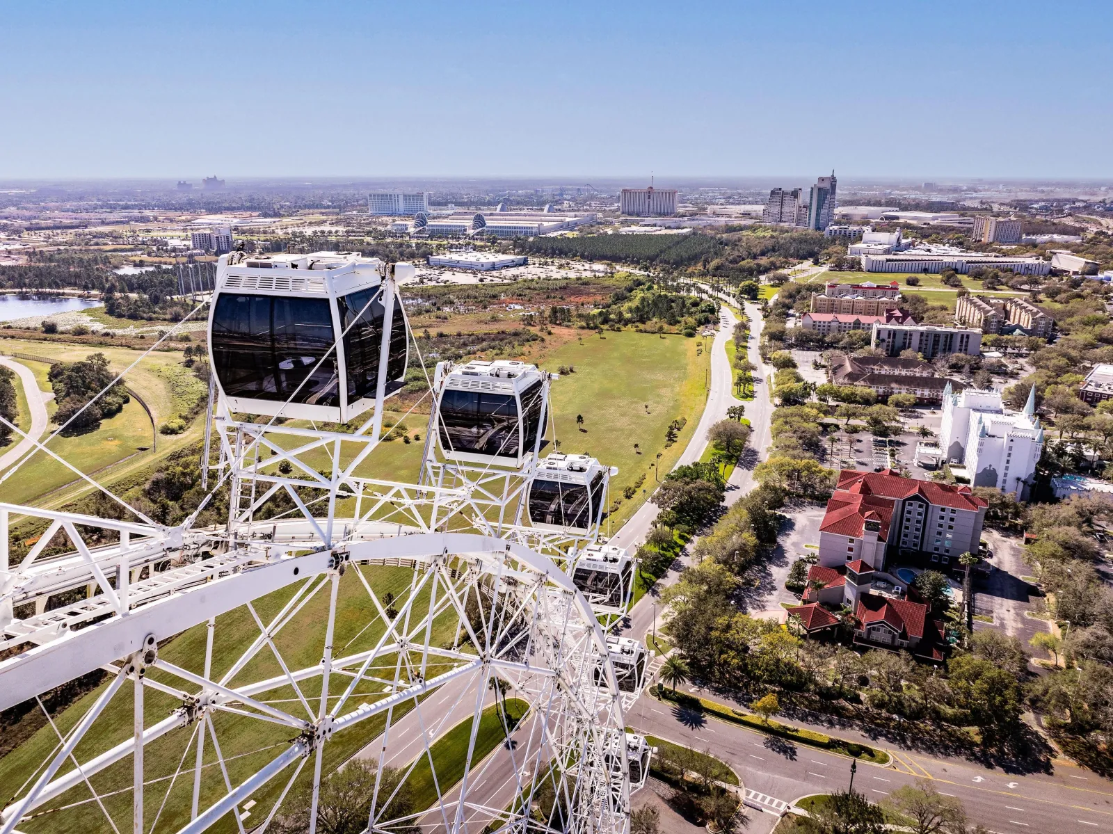 Aerial view past the wheel's white capsules toward International Drive hotels and the convention center