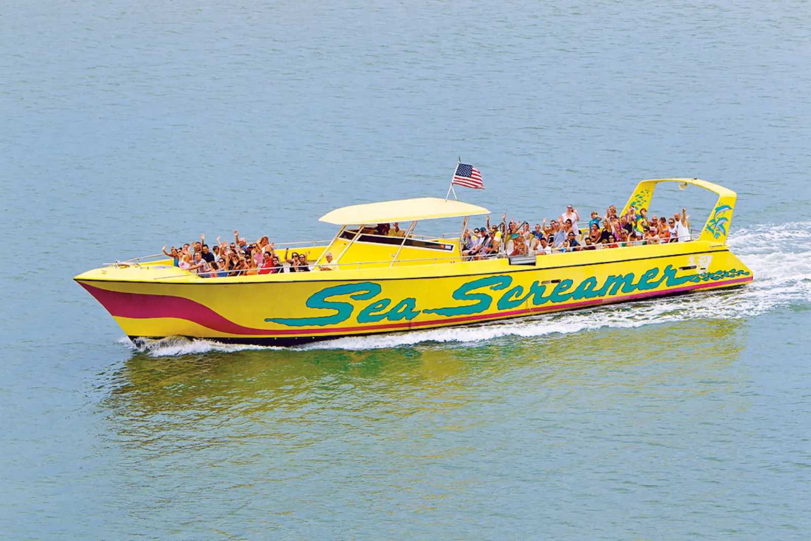 Yellow Sea Screamer speedboat full of waving passengers crossing calm water
