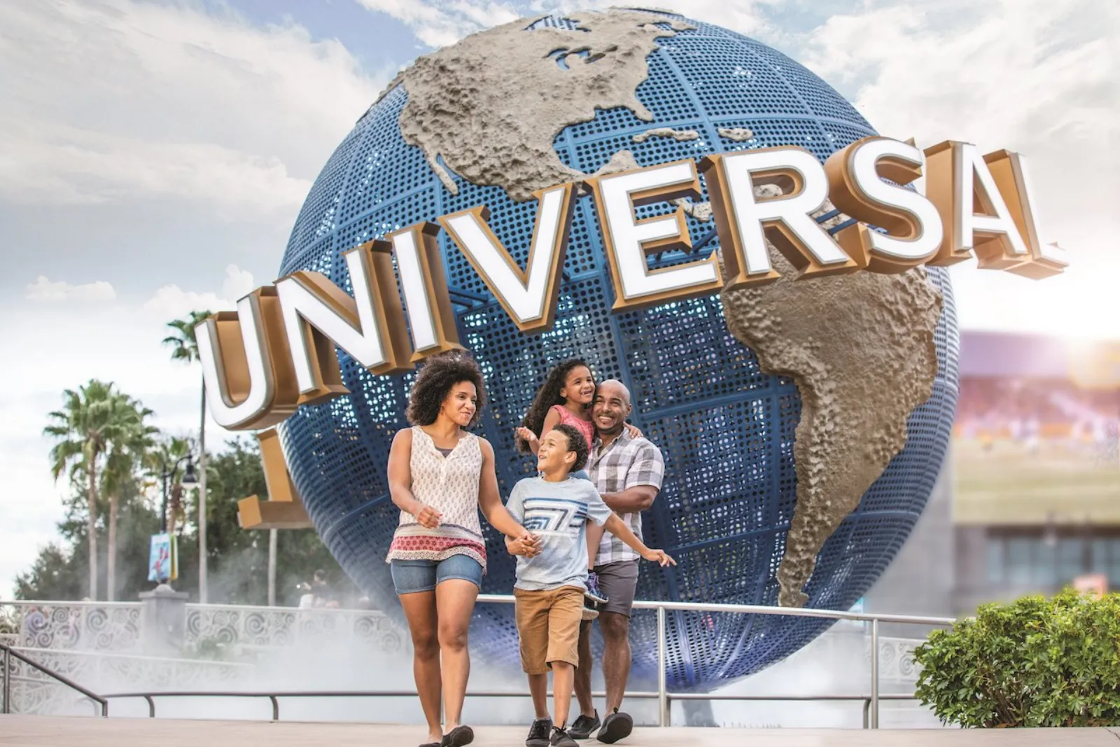 Family walking in front of the Universal globe sign on a sunny day