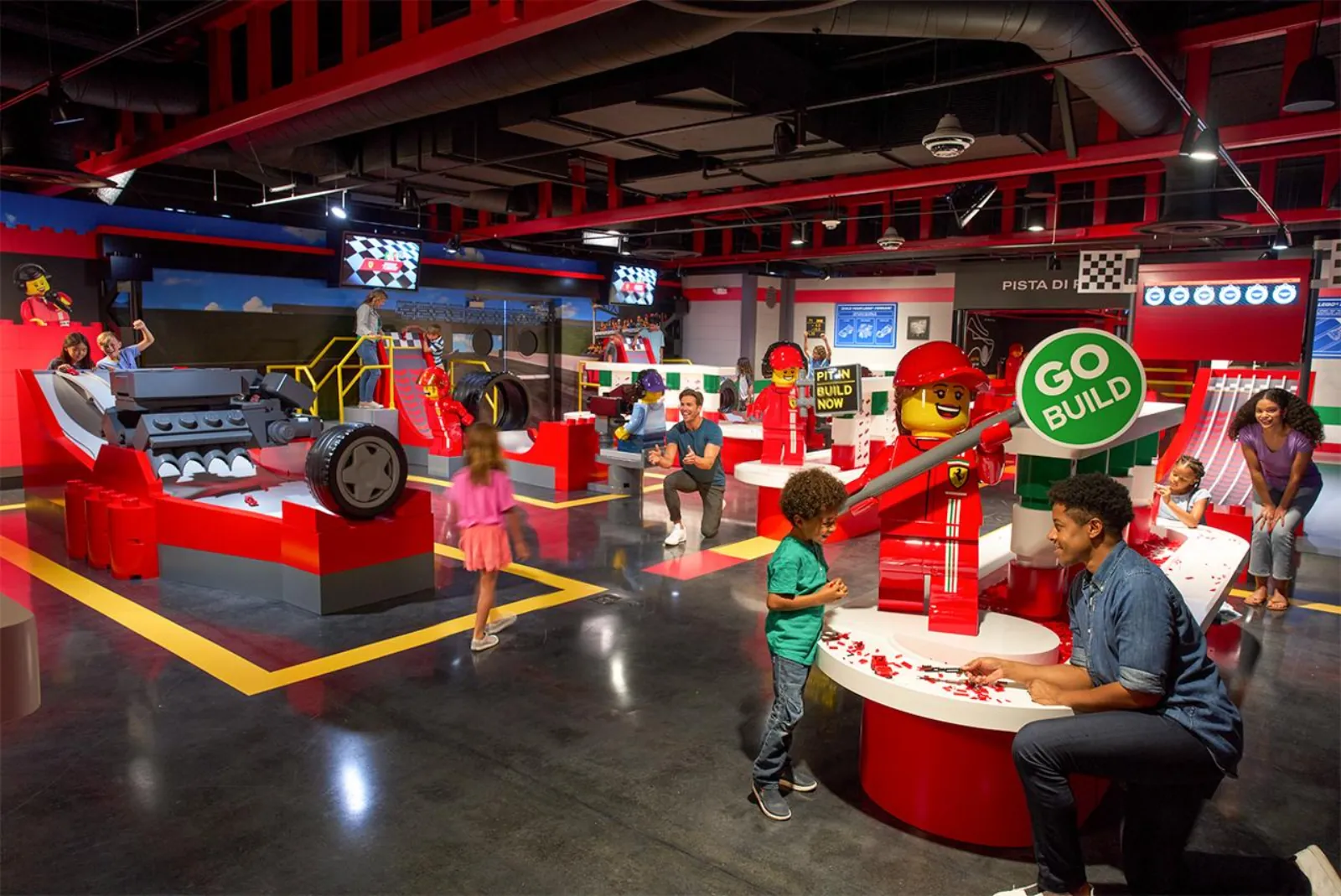 Kids and parents building LEGO cars at the Ferrari-themed build and race area