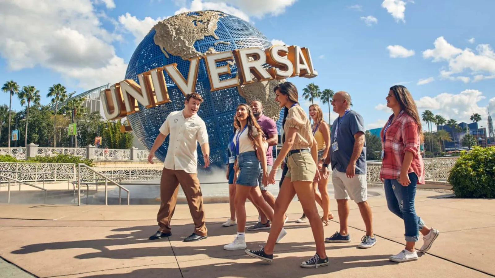 VIP guide leading a group of guests with lanyards past the Universal globe on a sunny day